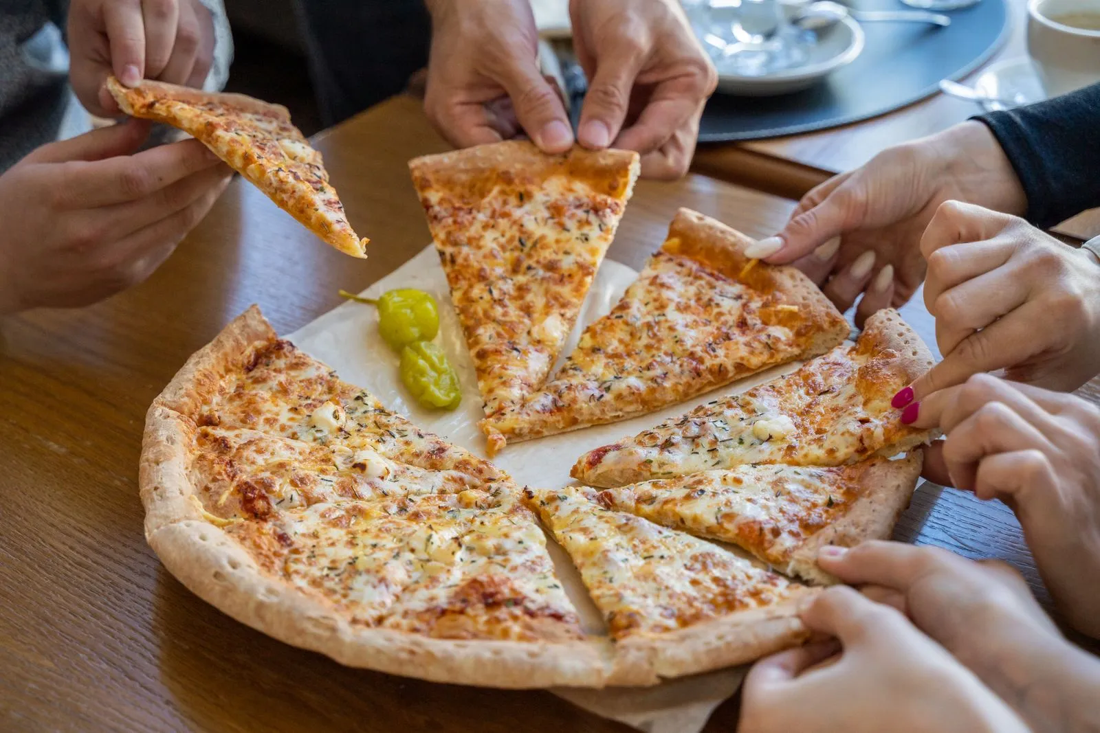 Pessoas compartilhando uma pizza à mesa
